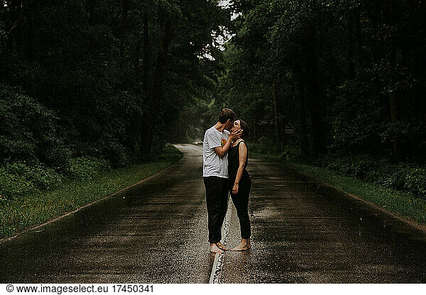 A couple in love kissing in the rain.