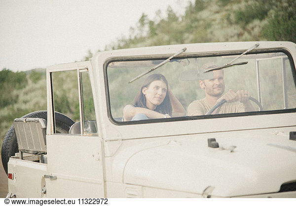 A couple on a road trip in the mountains in a jeep