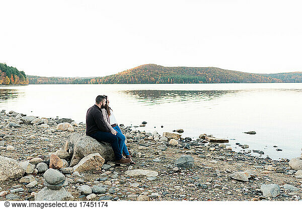 A couple sharing a tender moment by a serene lake