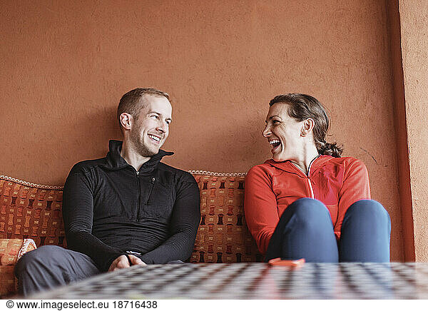 A couple smile at each other while sitting on a couch in Morocco