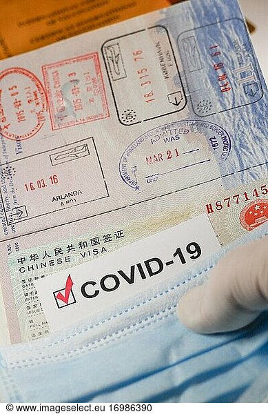 A Covid-19 immunization document and a Chinese Visa and a face mask.
