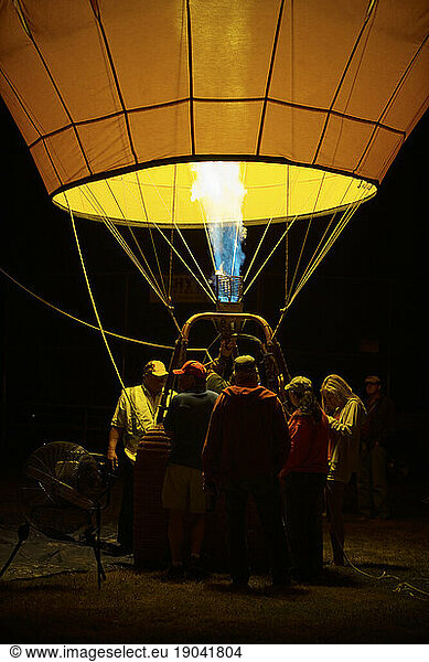 A crew steadies a newly inflated hot air balloon.