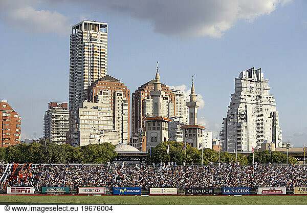 A crowded stadium with a cityscape of Buenos Aries in background.
