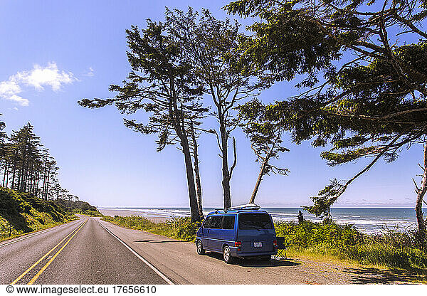 A Eurovan parked beside a two-lane road at the beach