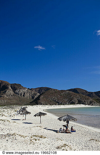 A family enjoys a secluded beach on a sunny  hot day outside La Paz  Mexico.