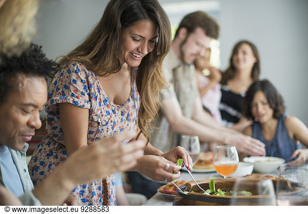 A family gathering for a meal. Adults and children around a table.