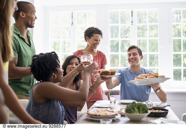 A family gathering  men  women and children around a dining table sharing a meal.