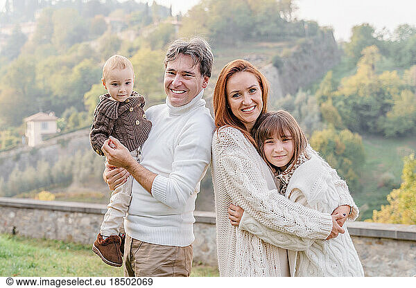 A family of four with a teenage girl and a toddler  holding hand