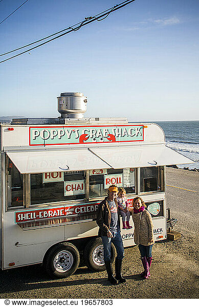 A family of three pose outside their seafood food truck on the coast near Pescadero  CA.