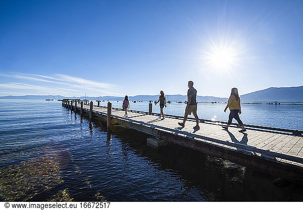 A family walks on a pier on a beautiful day in South Lake Tahoe  CA