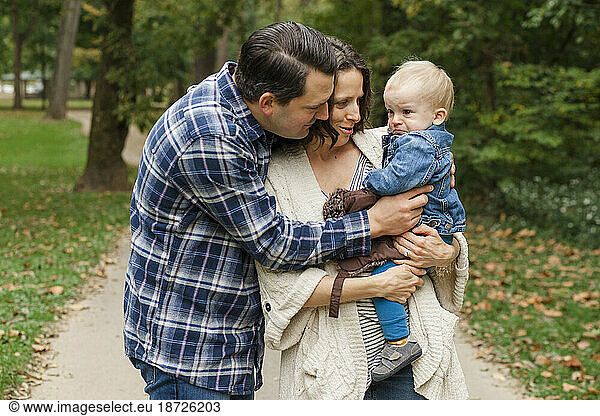 A father and mother lovingly comfort their sad little boy