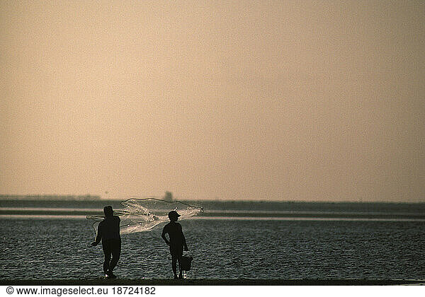 A father and son casting a bait net at San Luis Pass  close to Galveston Island  Texas.