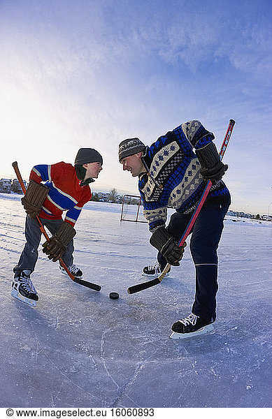 A father and son in a hockey faceoff; Alberta  Canada