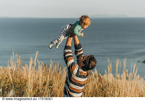 A father holds his baby girl outdoor