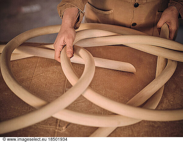 A female artist in her studio works with one of her wood sculptures