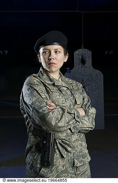 A female military police officer prepares to draw her pistol at the shooting range.