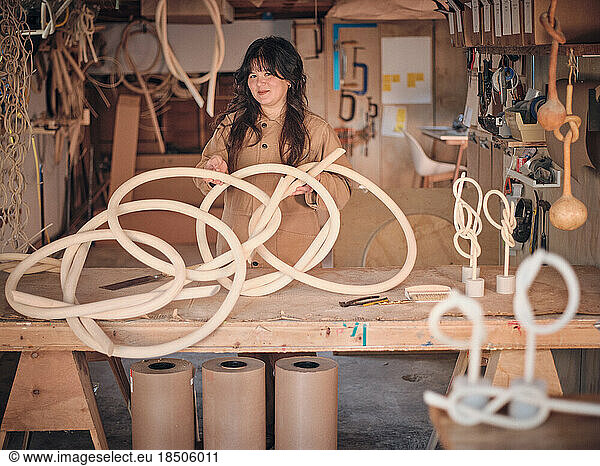 A female wood sculptor in her studio works with one of her pieces