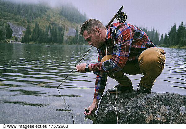 A flannel dressed fly fisherman lands a trout at Lake 22.