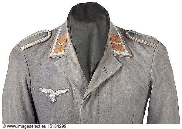 A flight tunic for an NCO of signals troops rare linen issue for the southern front Blue cotton twill in the cut of 'normal' flight tunics  covered fly with horn buttons  back liner and pocket sacks in bluish-green linen. Silver collar braid  brown collar tabs and edge cord  machine-embroidered breast eagle in blue woollen cloth  sewn-in shoulder boards in the base cloth. historic  historical  Air Force  branch of service  branches of service  armed service  armed services  military  militaria  air forces  object  objects  stills  clipping  clippings  cut out  cut-out  cut-outs  20th century