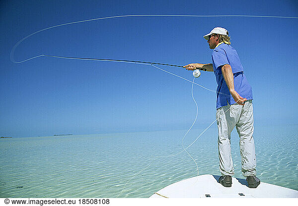 A fly-fisherman casts his line in the Bahamas.