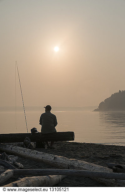 A fly fisherman taking a break from fly fishing relaxing by the water