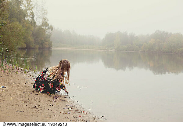 A foggy morning lake view with a little girl with wild hair