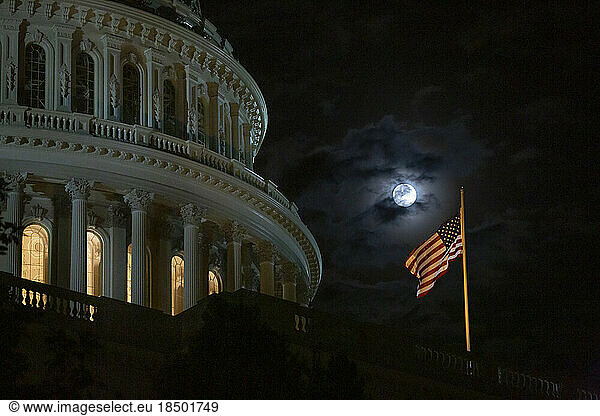 A full moon rises above the U.S. Capitol Building in Washington.