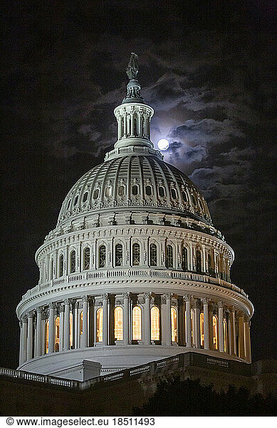 A full moon rises above the U.S. Capitol Building in Washington.