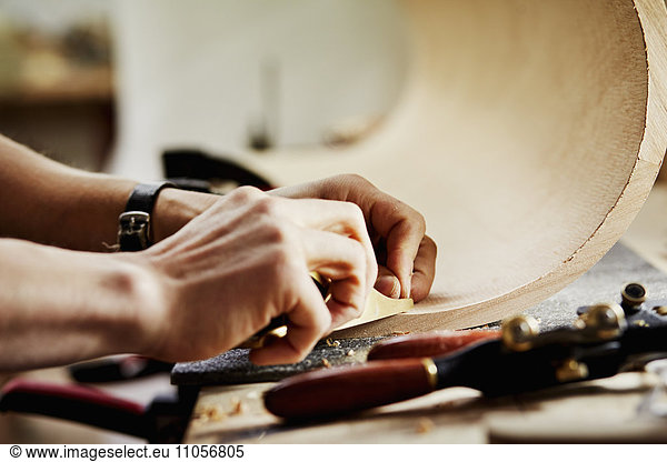 A furniture workshop making bespoke contemporary furniture pieces using traditional skills in modern design. A man working on a piece of curved wood.