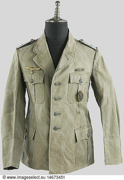 A German coastal artillery oberleutnant jacket.  Sun-washed thick green canvas  golden eagle and buttons  twisted shoulder boards  coastal artillery breast badge made by 'Schwerin Berlin' originally sewn on the breast pocket. Background shadow of Feldspange and 'Minen Sucher' insignia. Untouched jacket since the end of the war.  historic  historical  1930s  1930s  20th century  navy  naval forces  military  militaria  branch of service  branches of service  armed forces  armed service  object  objects  stills  clipping  clippings  cut out  cut-out  cut-outs  uniform  uniforms  clothes  textile  outfit  outfits  wearings
