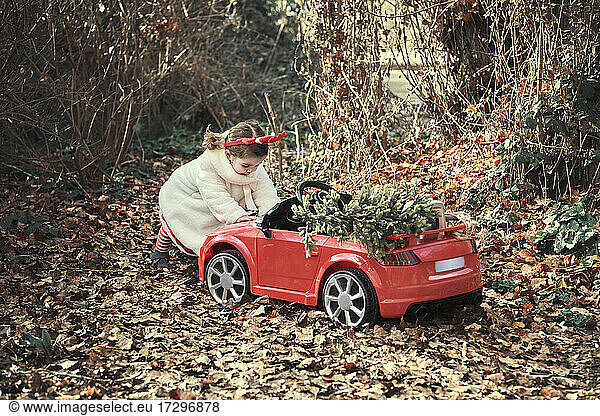 A girl in a christmas outfit in her red car