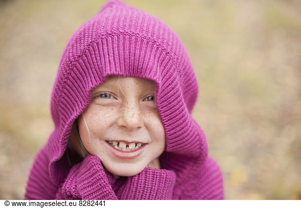 A Girl In A Magenta Hooded Sweater  With The Hood Covering Her Head