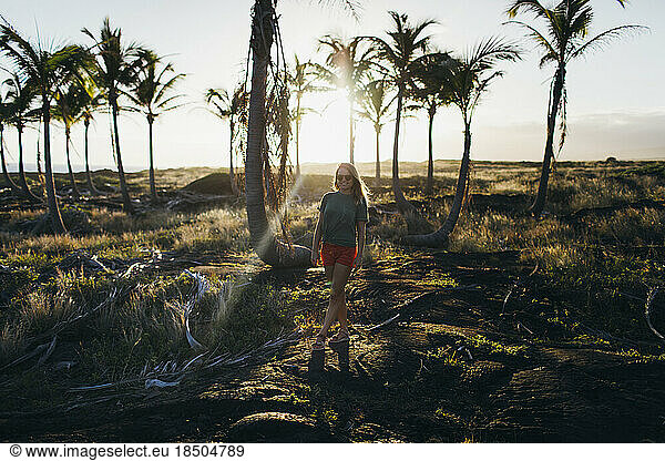 A girl is walking on lava rocks near the ocean  Big Island  Hawaii.
