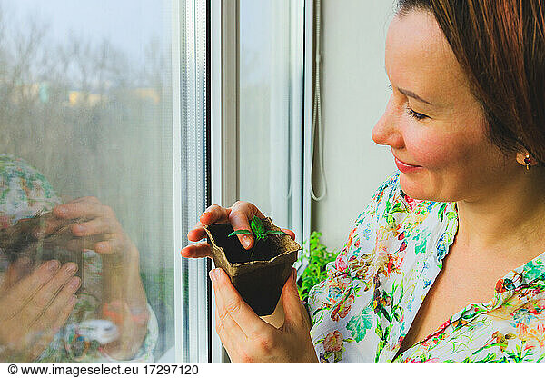 A girl photographs potted plants that she has grown in her home garden
