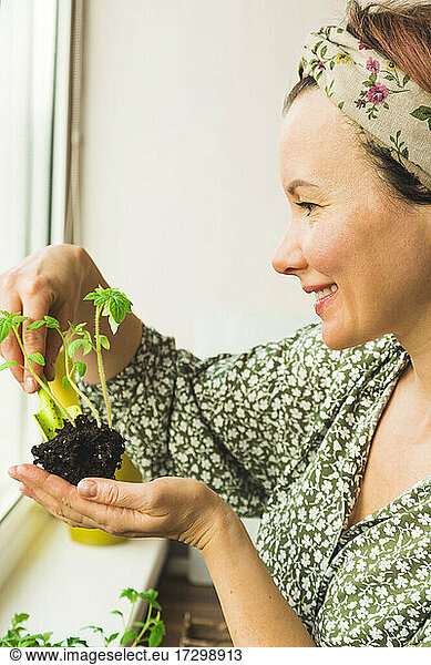 A girl photographs potted plants that she has grown in her home garden