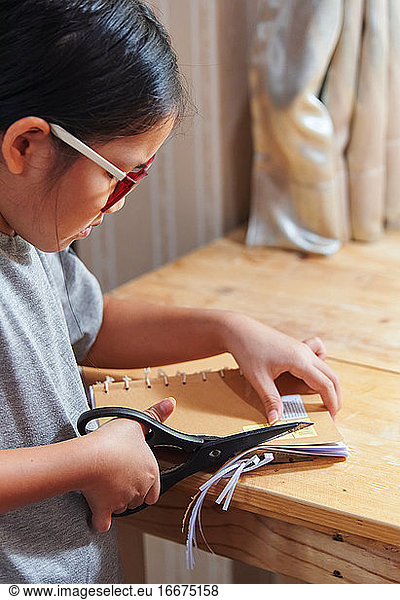 A girl trimming the hand craft book