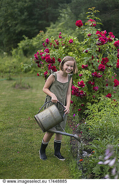 A girl watering flowers in the garden.