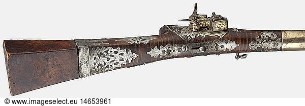 A gold-inlaid Ottoman miquelet rifle  circa 1800 Lightly swamped octagonal barrel with a seven-groove rifled bore in 14 mm calibre. The entire top of the barrel is inlaid with gold floral ornamentation (spaces at the barrel rings) all the way to the muzzle. Gold-inlaid miquelet lock  replaced at the period the arm was in use. Maple full stock with a green bone nose cap. Numerous stamped openwork silver pieces are attached with nails to the butt stock and the lock area. Five silver barrel rings with gilding and floral engraving. Iron ramrod with ball puller. Length 108.5 cm. historic  historical  19th century  Ottoman Empire  firearm  fire arm  gun  fire arms  firearms  guns  handgun  weapon  arms  weapons  arms  object  objects  stills  clipping  clippings  cut out  cut-out  cut-outs