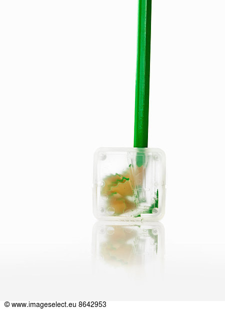 A green pencil and clear plastic pencil sharpener.