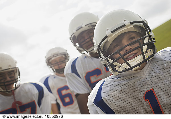 A group of football players,  members of a squad,  young people in sports uniform and protective helmets,  heads and shoulders.