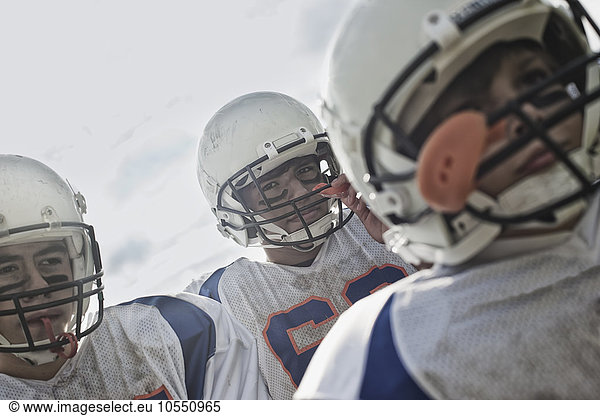 A group of football players  members of a squad  young people in sports uniform and protective helmets  heads and shoulders.