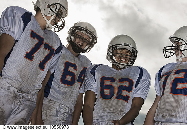 A group of football players  members of a squad  young people in sports uniform and protective helmets  heads and shoulders.