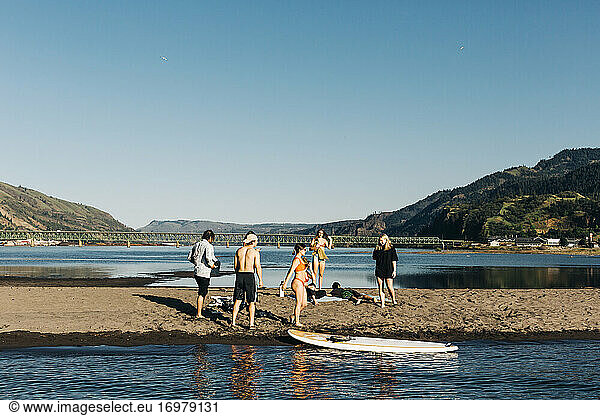 A group of people enjoy the sand spit in the Columbia River.