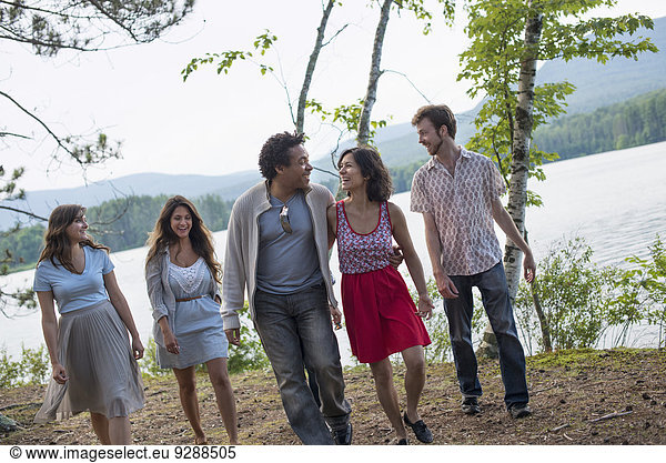 A group of people enjoying a leisurely walk by a lake.