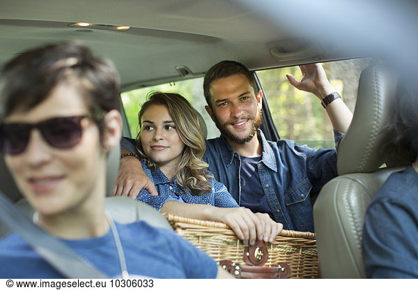 A group of people inside a car  two in the back seat and two in the front.