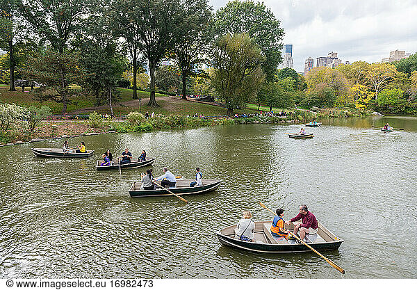 A group of people rowing in small boats at Central Park lake