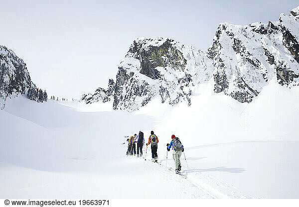 A group of skiers in the backcountry on a clear day.