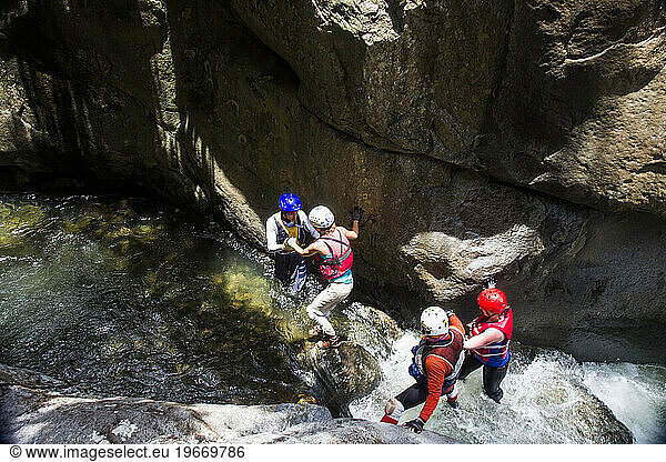A group of tourists enjoy a waterfall adventure that involves rappelling and swimming in Puerto Rico.