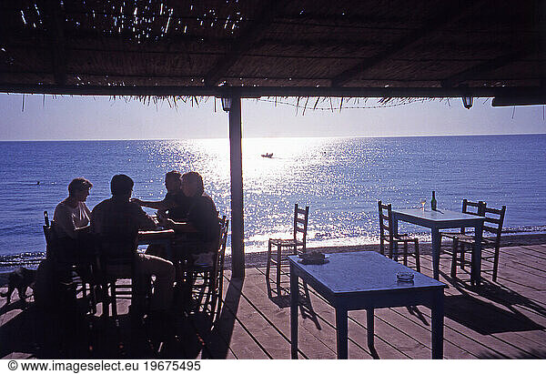 A group of tourists relaxing in a beachfront Taverna at Skala Eressos.