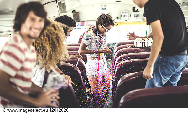 A group of young people in a party on a school bus.